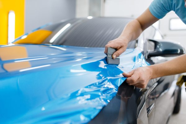 car-wrapping-mechanic-with-squeegee-installs-film-2021-08-28-13-40-12-utc